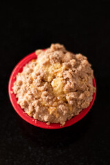 Freshly backed homemade cupcake on black glossy surface shallow depth of field top view