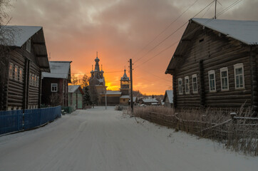 Dawn in the northern village of Kimzha. Temple in the name of the Odigitrievskaya Icon of the Mother of God, village houses and fences. Russia, Arkhangelsk region, Mezensky district 