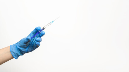 Hand nurse in medical glove holding syringe with an injection on white background, copy space....