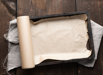 empty rectangular metal pan covered with brown parchment paper and paper rolls