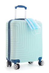 Obraz premium Medical mask on a blue suitcase for travel.