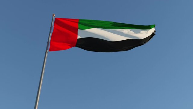 Beautiful waving UAE flag in the sky close up. Realistic background United Arab Emirates flags.