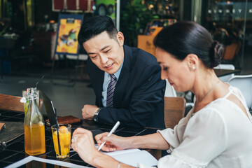 Business contract signing. Businesswoman signs formal paper with pen on table. Business partners having a successful meeting in cafe.