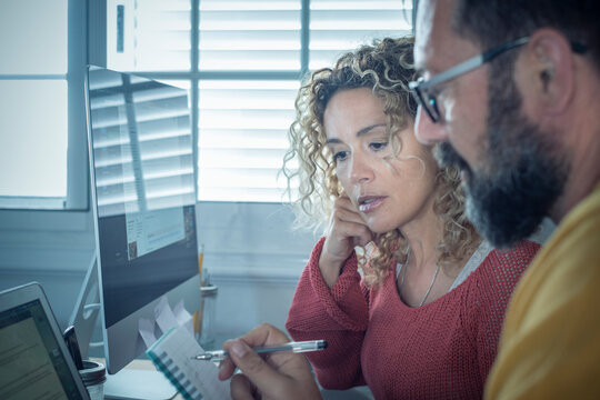 People at work at home with internet connection and computer laptop in couple - man and woman working together - modern man and woman online job activity in alternative house office