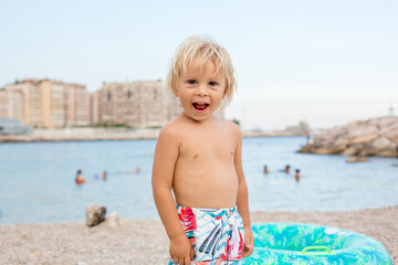 Cute blond toddler child, boy, drinking vitamin pills