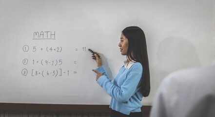 Teacher taught the book with a bright smile, Students raised their hands to answer questions with courage, Mathematics education in a high school or university classroom.