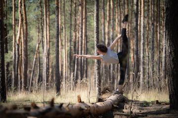 Flexible female gymnast makes exercise in the forest. Healthy lifestyle 