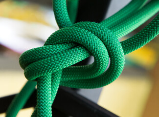 Close up green rope with knot on selective focus background