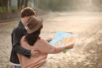 Couple of travelers with map on city street