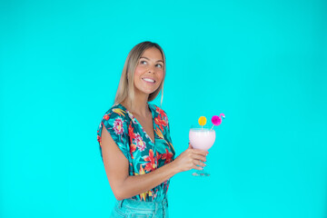 Blond woman with a drink on blue background smiling