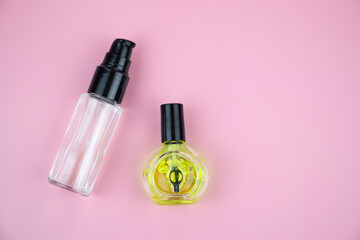 nail oil and body spray on a pink background, flat lay