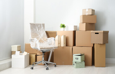 Cardboard boxes and packed chair indoors. Moving day