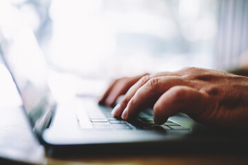 Man typing message on laptop during work