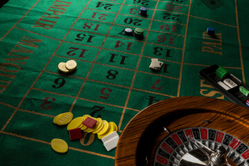 Roulette in legno isolata sopra un tavolo da gioco verde con fiches colorate