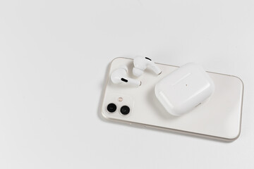 white wireless headphones on a white background. White smartphone