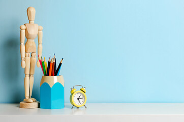 Concept of school items on the home desk on a blue background. Place for text.