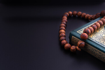 Holy Quran with arabic calligraphies translation meaning of Al-Quran and Rosary or Tasbih on black...