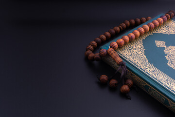 Holy Quran with arabic calligraphies translation meaning of Al-Quran and Rosary or Tasbih on black...