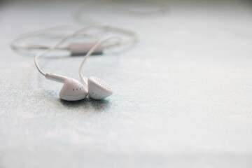 Fototapeta premium White Headphones On A blue Background, Earphone, accessory.
