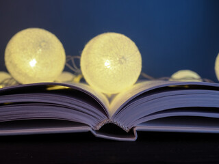 A burning garland of balloons lies on an open book