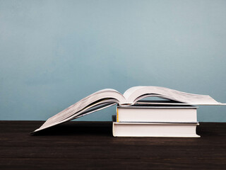 a stack of several books, close-up, open book in the foreground