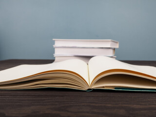 a stack of several books, close-up, open book in the foreground