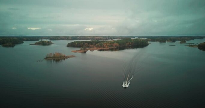 Fast solo Yacht sailing in calm river waterway with scattered islands, fall season