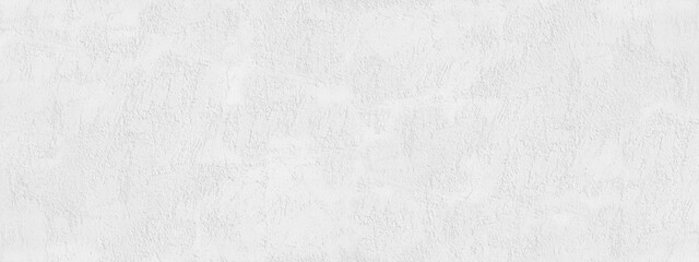 White rough decorative plaster on a concrete wall. Cement texture. Close-up. Modern grunge background with copy space for design. Wide banner.