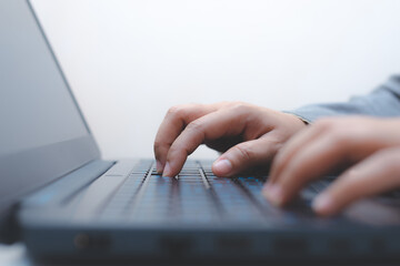close-up of business woman hand typing and using laptop keyboard for searching with technology networking on working and job on desk at work place or work at home.