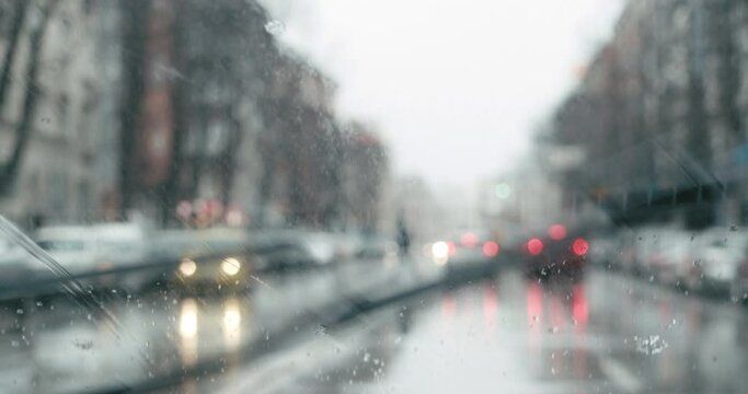 Snowing on car windshield with wipers working while driving