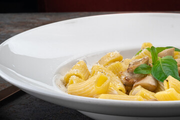 Mezze maniche or rigatoni pasta with cream sauce, parmesan and mushrooms. Italian Cuisine Recipe, macro