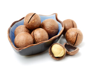 Shelled and unshelled macadamia nuts on white background