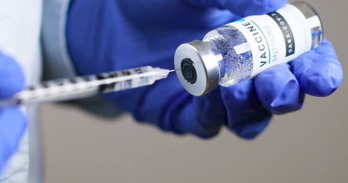Doctor or nurse in protective medical rubber gloves holds new vaccine and syringe against coronavirus Sars-cov-2, coronavirus or covid-19