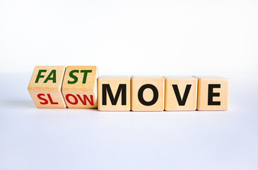 Time to fast move symbol. Turned wooden cubes and changed words 'slow move' to 'fast move'. Beautiful white table, white background, copy space. Business and slow or fast move concept.