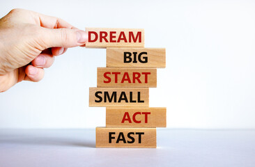 Dream big start small symbol. Words 'dream big start small act fast' on wooden blocks on a beautiful white background. Businessman hand. Business, motivational and dream big start small concept.