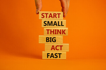 Start small think big symbol. Words 'Start small think big act fast' on wooden blocks on a...