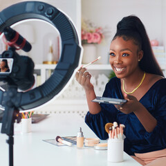 happy young african american woman streaming a beauty vlog from home, online content creator...
