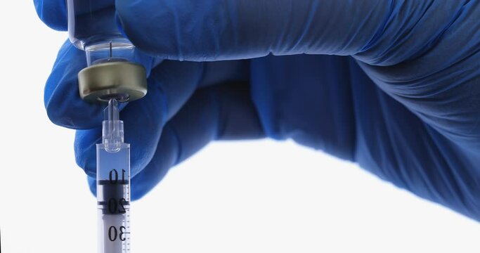 Close up of medical nurse or doctor hand in safety gloves holds a syringe and vaccine bottle. Doctor uses hypodermic needle and a syringe to put a shot of drug as treatment. Health medical concepts.
