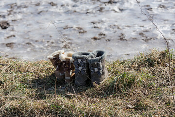 Schuhe am Rand eines zugefrorenen Sees im Winter