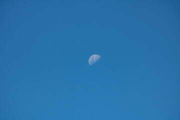 Moon in the blue sky during the day