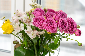 Beautiful flowers in vase with light from window