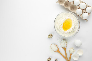 Fototapeta na wymiar Eggs and quail eggs and sugar, coconut shavings in wooden spoons 