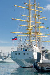 Naklejka premium Sailboat on the background of the sea and the urban landscape