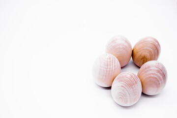 Five hand-made unpainted wooden eggs on a white background