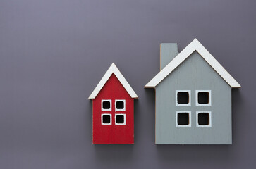 Wooden models of houses. Rent, buying or mortgage concept. Gray background. Copy space.