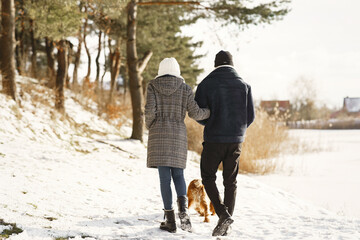 Fototapeta na wymiar People walks outside. Winter day. African couple with dog.