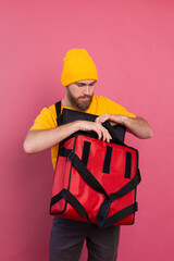 European bearded delivery man open box with food  pink background isolated
