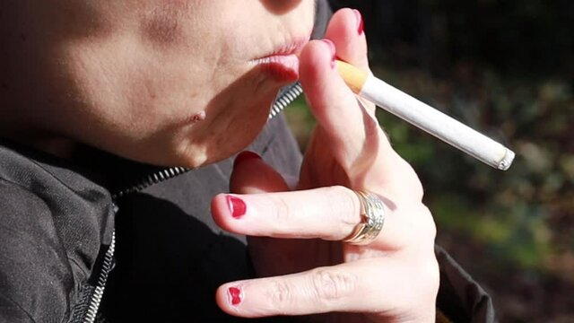 gros plan sur une femme allumant une cigarette