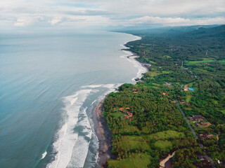 Aerial view of coastline with black sand beaches and waves in Balian