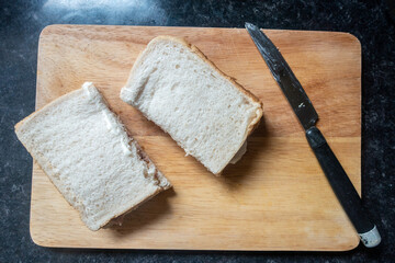 A homemade sandwich on a wooden chopping board.